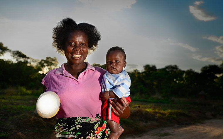 Woman and Child holding solar light Solaraid